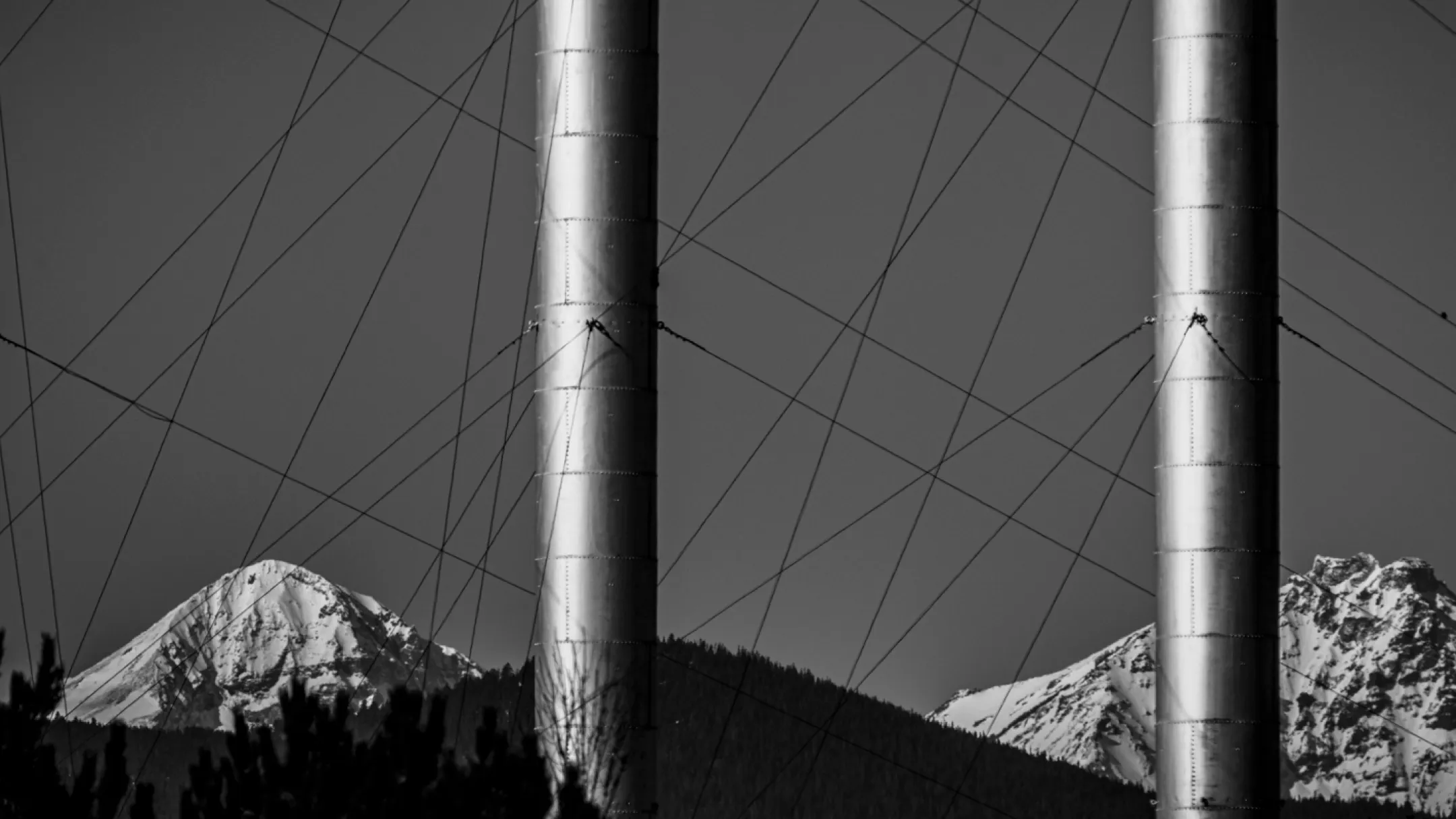 Industrial metal towers with snowy mountain backdrop view from Baldhead Cabinets company